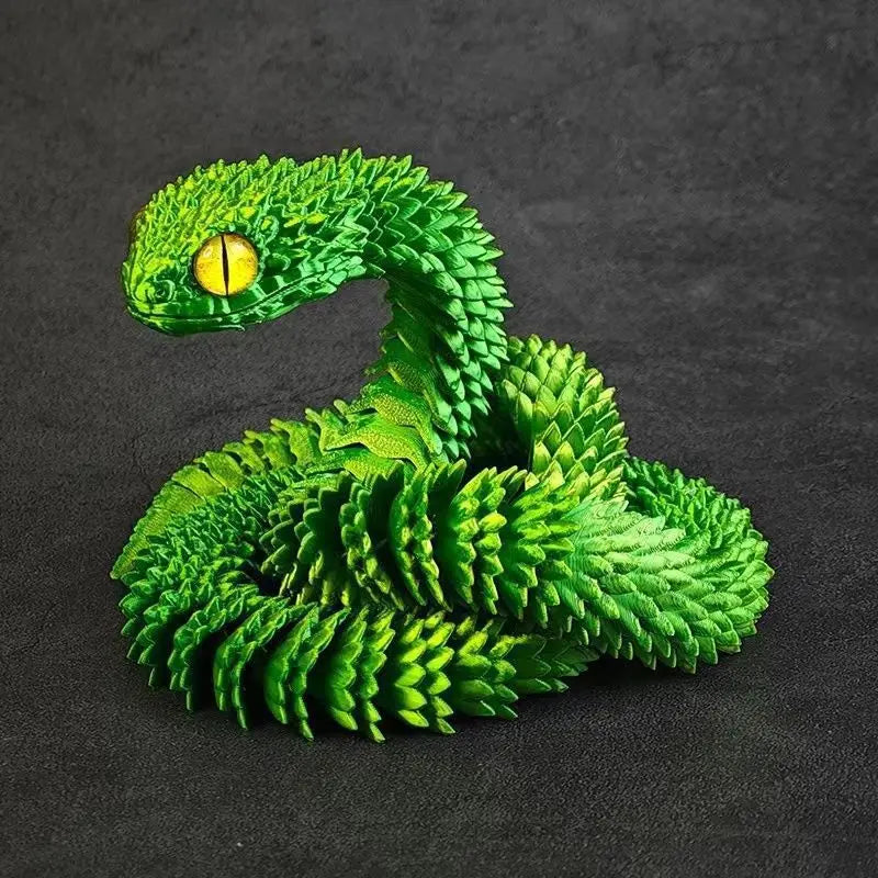 A vibrant green 3D printed rotatable snake art model with a yellow eye, resting on a dark surface.