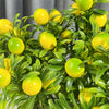 A close-up of a branch with four artificial lemon-green and yellow fruit stems.