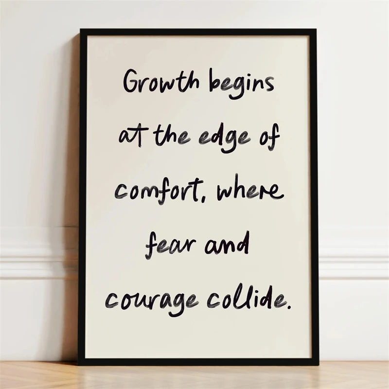A framed print with black text on a white background that reads Growth begins at the edge of comfort where fear and courage c