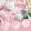 A white cheesecloth block and a white rose flower displayed on a rustic pink fabric background.