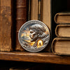 A commemorative coin featuring Jesus Christ with a crown of thorns and the inscription He Is Risen set against a mountainous 