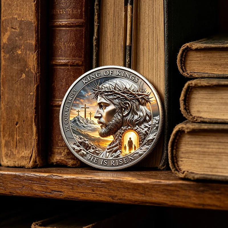 A commemorative coin featuring Jesus Christ with a crown of thorns and the inscription He Is Risen set against a mountainous 
