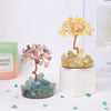 A small crystal tree featuring purple and yellow quartz crystals used as home decor.