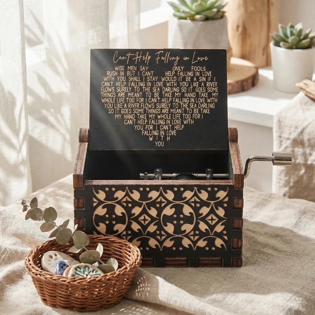 An antique wood music box with an engraved melody sits in a wooden box on a linen cloth.