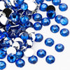 A close-up view of numerous round blue resin rhinestones scattered on a white background.
