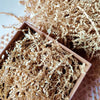 A pile of light brown crinkle cut paper shred filler material.
