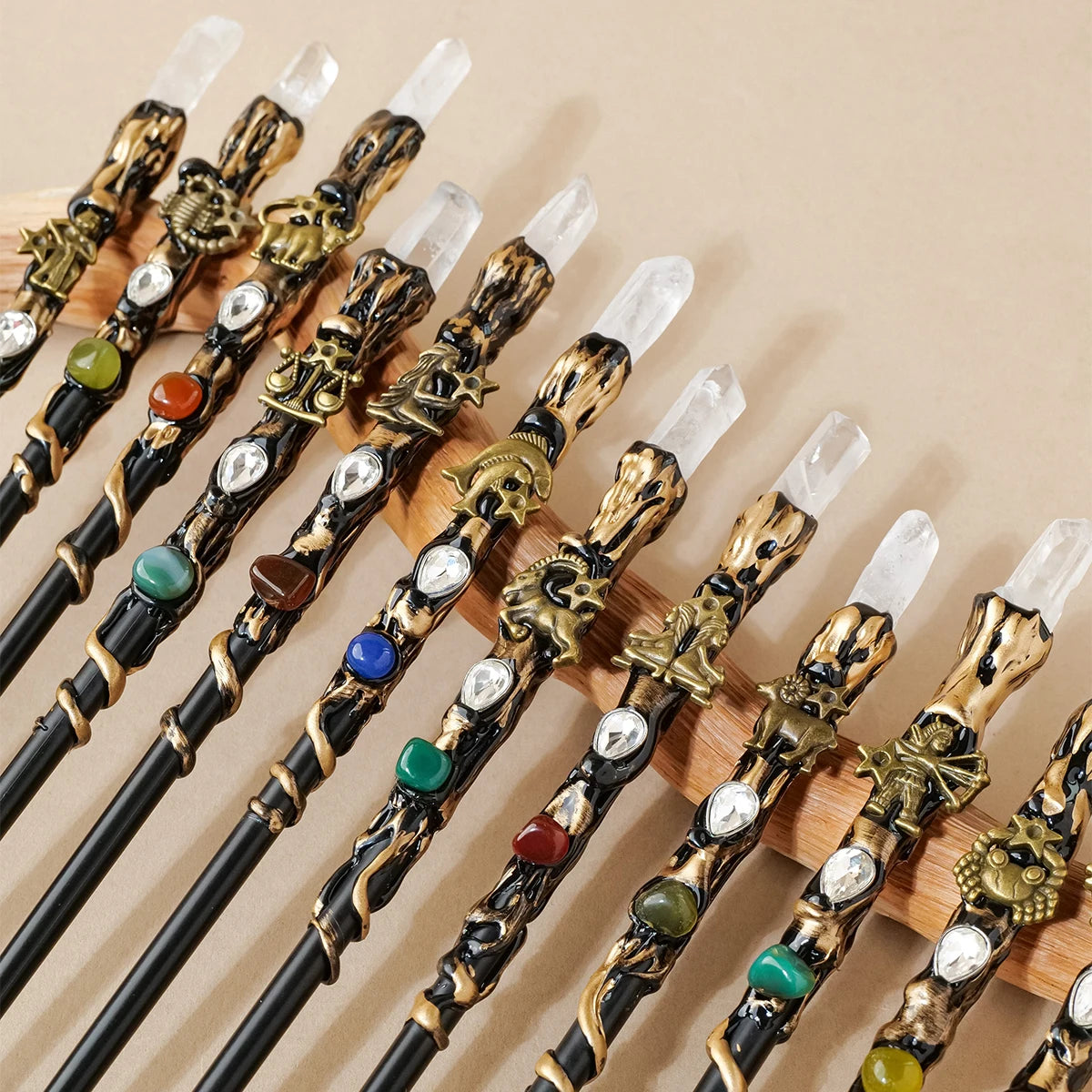 A collection of natural clear quartz zodiac crystal wands with decorative handles arranged diagonally.