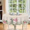 A beige floral tablecloth with rose and daisy print is displayed on a white table set for tea.