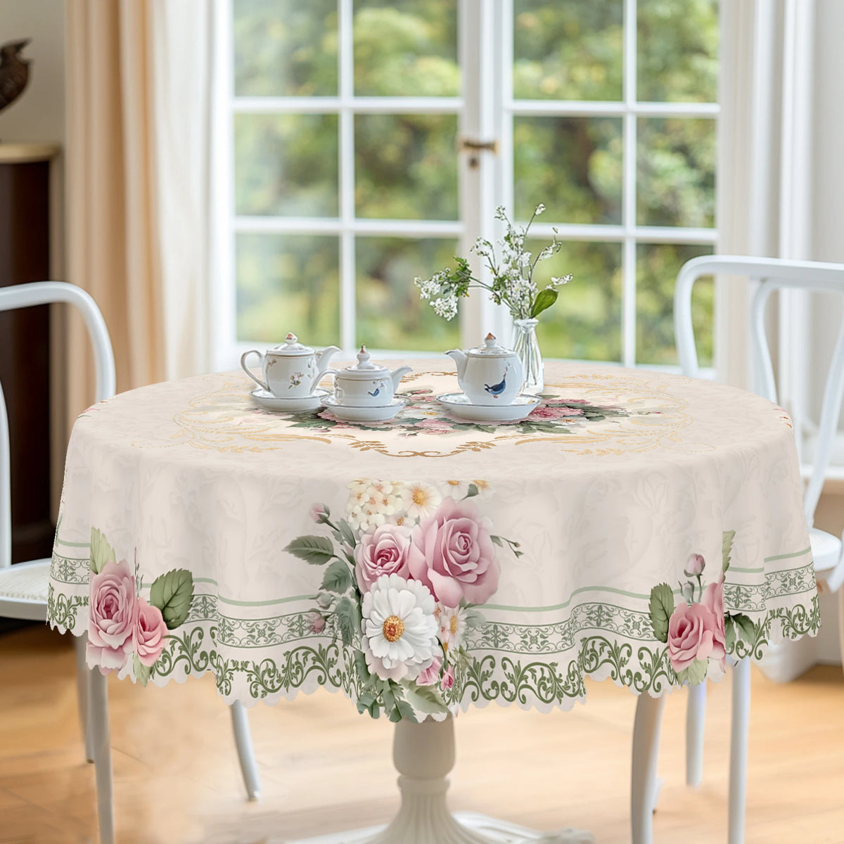 A vintage French floral tablecloth set with teaware displayed on a white dining table.