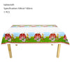 A tablecloth featuring a farm theme with red barns, animals, and flowers for a birthday party decoration.