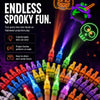 A hand holds an assortment of Halloween LED finger projector lights casting spooky patterns on a dark background.