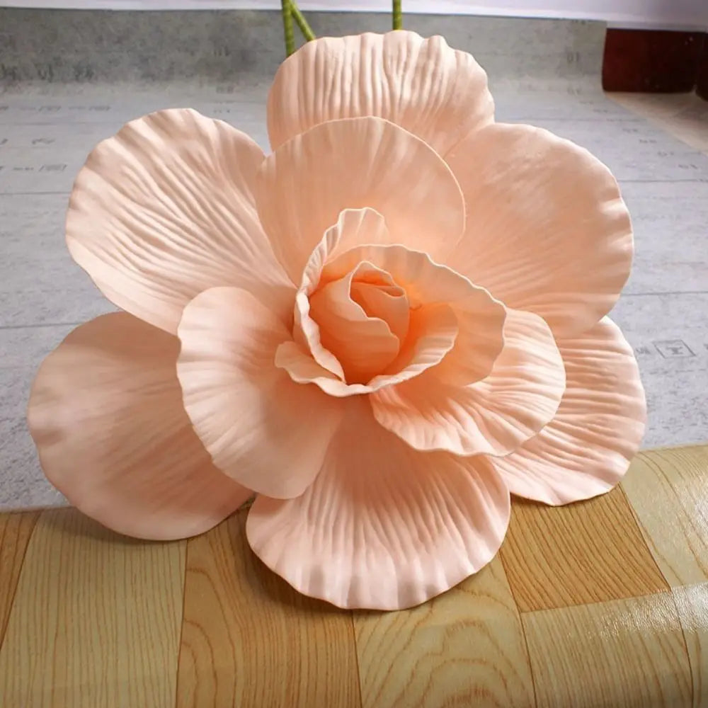 A large, peach-colored silk foam rose bloom with layered petals and a green stem.