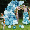 Una gran exhibición de globos azules claros y oscuros dispuestos en forma de árbol con follaje floral.