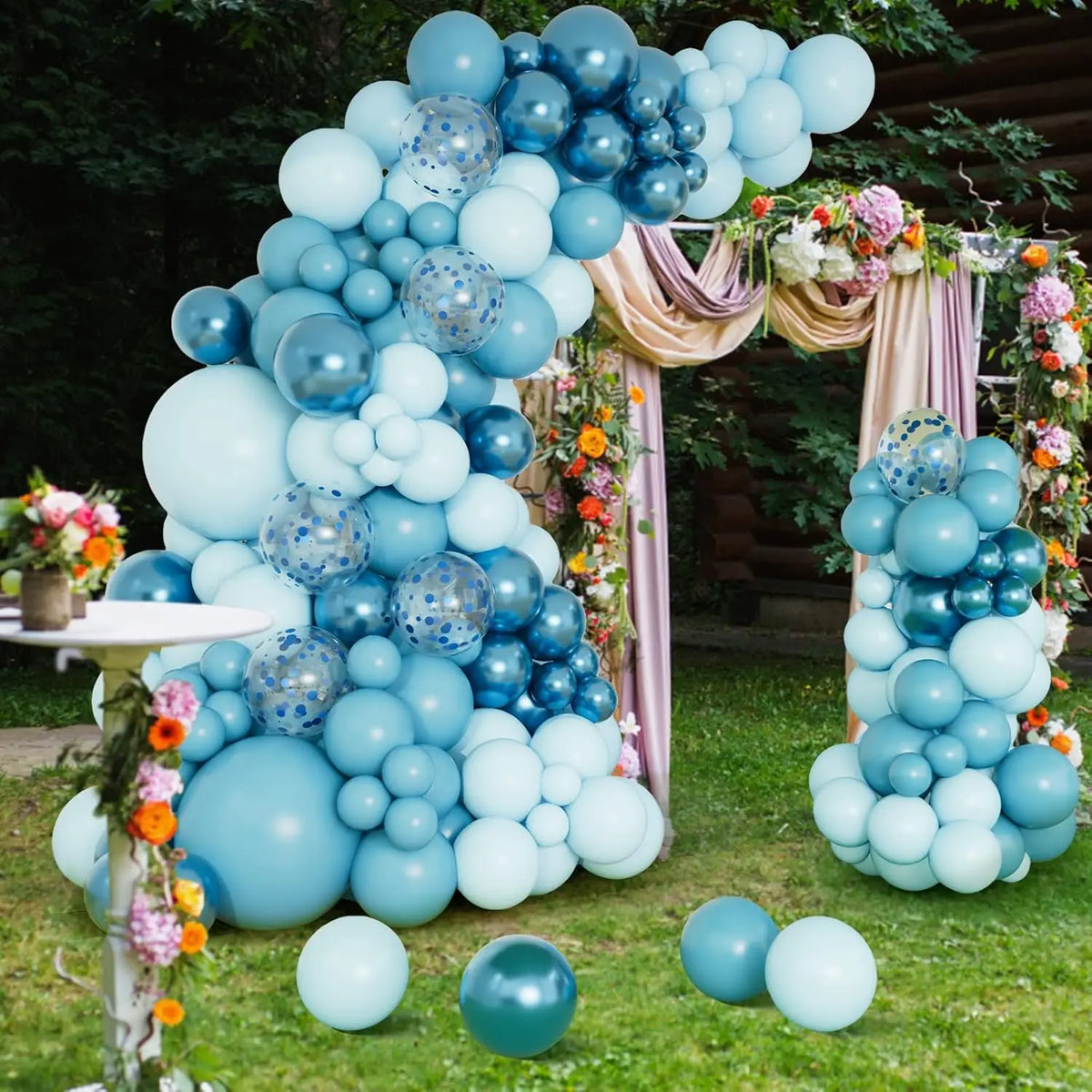 Una gran exhibición de globos azules claros y oscuros dispuestos en forma de árbol con follaje floral.