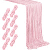 A rustic pink semi-sheer gauze table runner draped and folded.