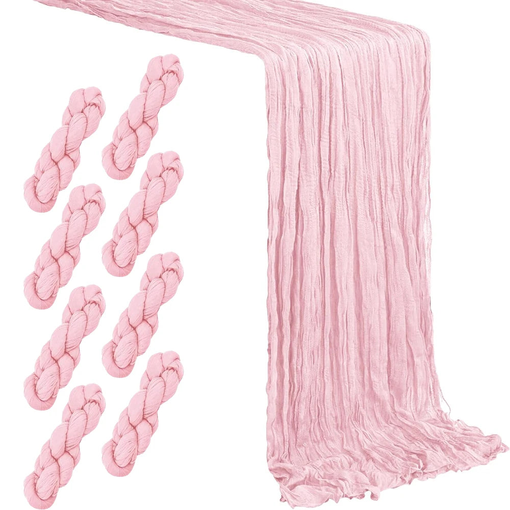 A rustic pink semi-sheer gauze table runner draped and folded.