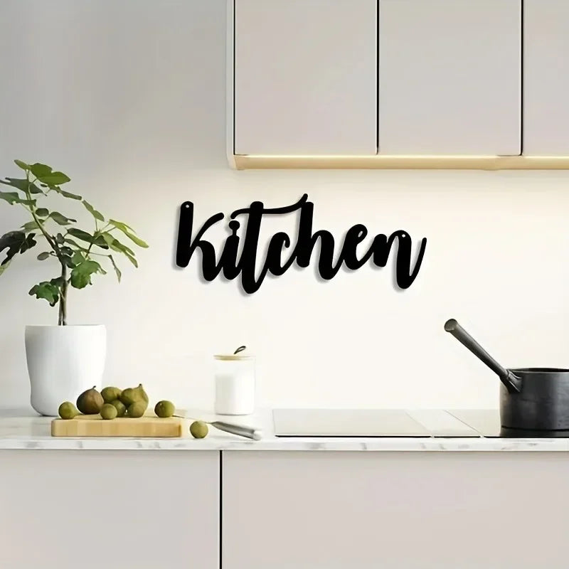 Black script wall art spelling kitchen on a white kitchen backsplash