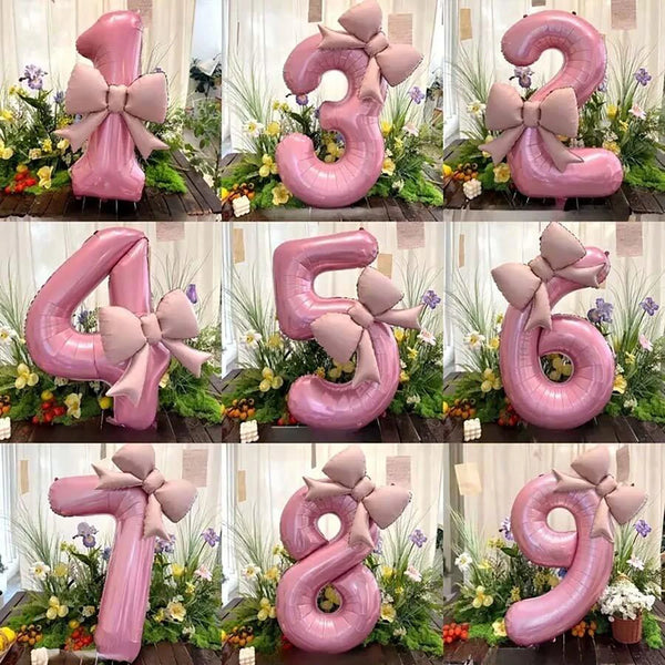 A set of pink 32-inch number balloons shaped like the numbers 1 through 9 with matte bow decor displayed in a floral arrangem