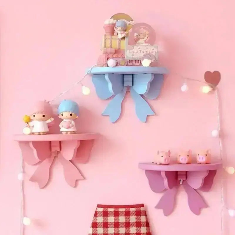 A pink wall shelf featuring decorative bow-shaped wooden shelves and a small figurine.