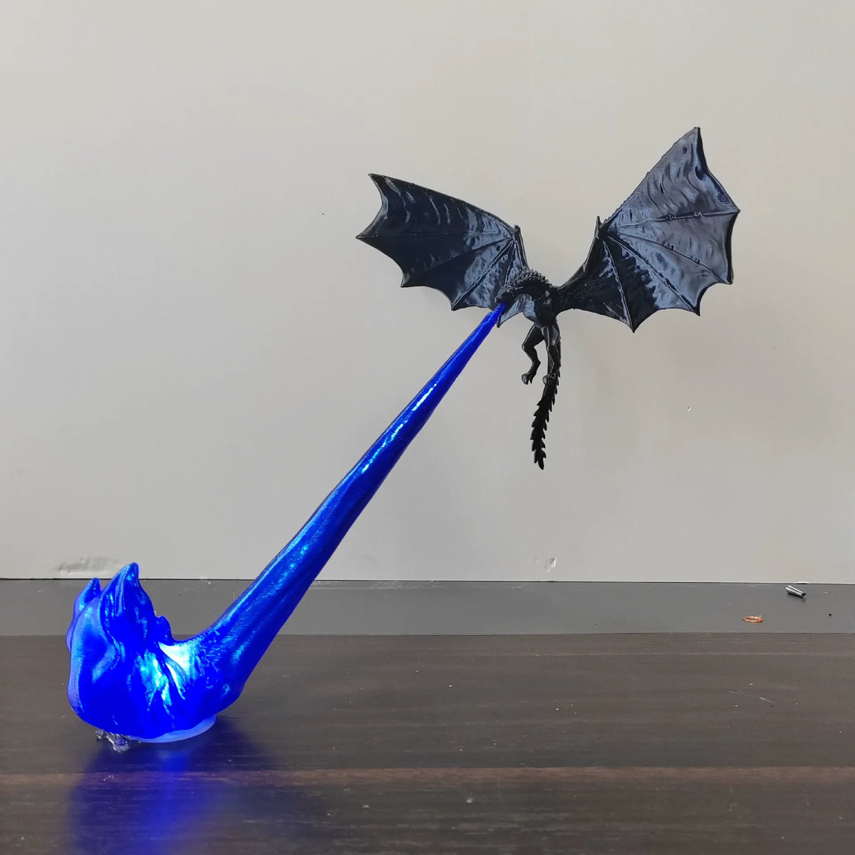 A blue dragon flame light fixture with a black bat-like wing design.