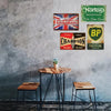 A collection of vintage metal tin signs featuring motorcycle and automotive themes displayed on a gray textured wall.