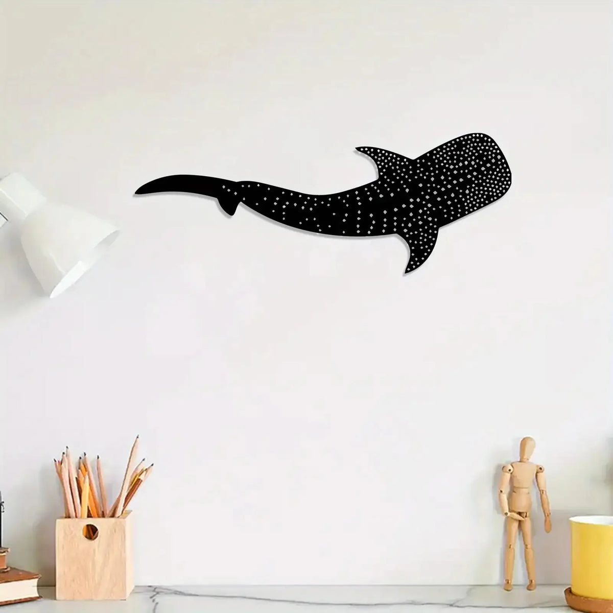 Black silhouette of a whale shark with white polka dots mounted on a white wall.