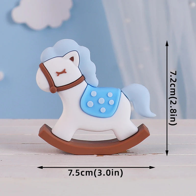 A white horse baby block topper featuring a light blue mane and bridle, mounted on a brown base.