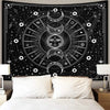 A black tapestry wall hanging featuring a white psychedelic sun and moon mandala design.