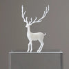 A white resin ornament of an elk deer with antlers standing on a clear glass base.
