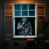 A horror carnival clown figure with white face paint and red blood dripping, displayed in a window setting.