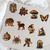 A collection of dark, gothic, and retro-themed stickers featuring bats, spiders, witches, and other spooky motifs on a white 