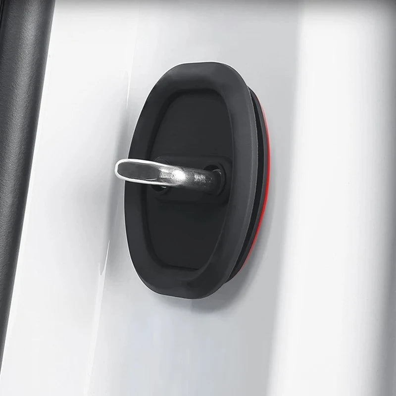 A close-up of a black silicone door lock protector with a silver handle mounted on a white surface.