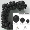 A black balloon garland arch made of round balloons, shown in a close-up with accessories.