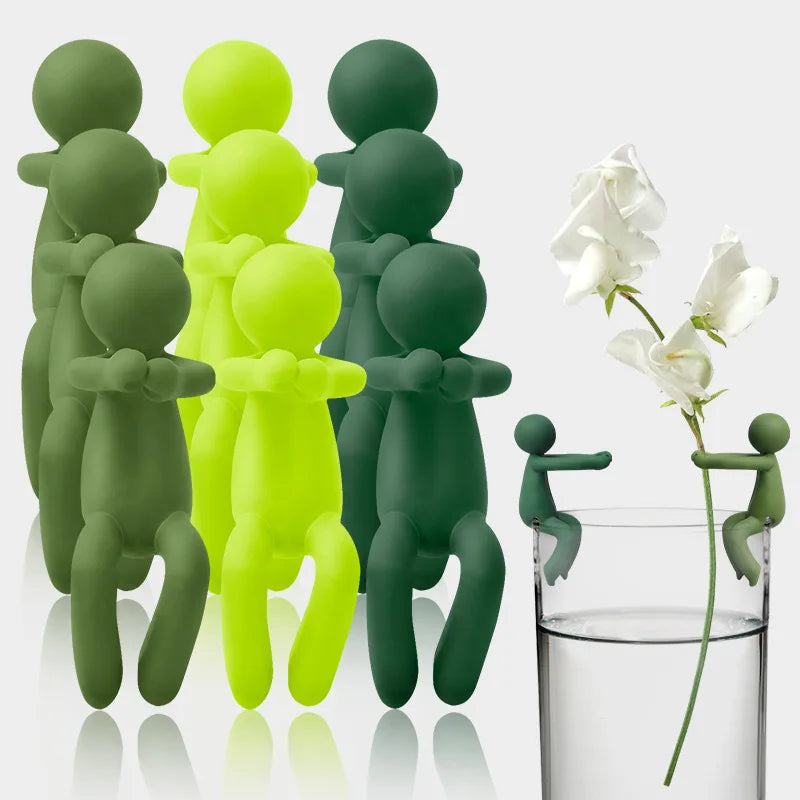 A set of three human-shaped plant supports in shades of green and lime yellow standing upright.