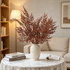 A vase filled with artificial silk lover grass on a white table setting