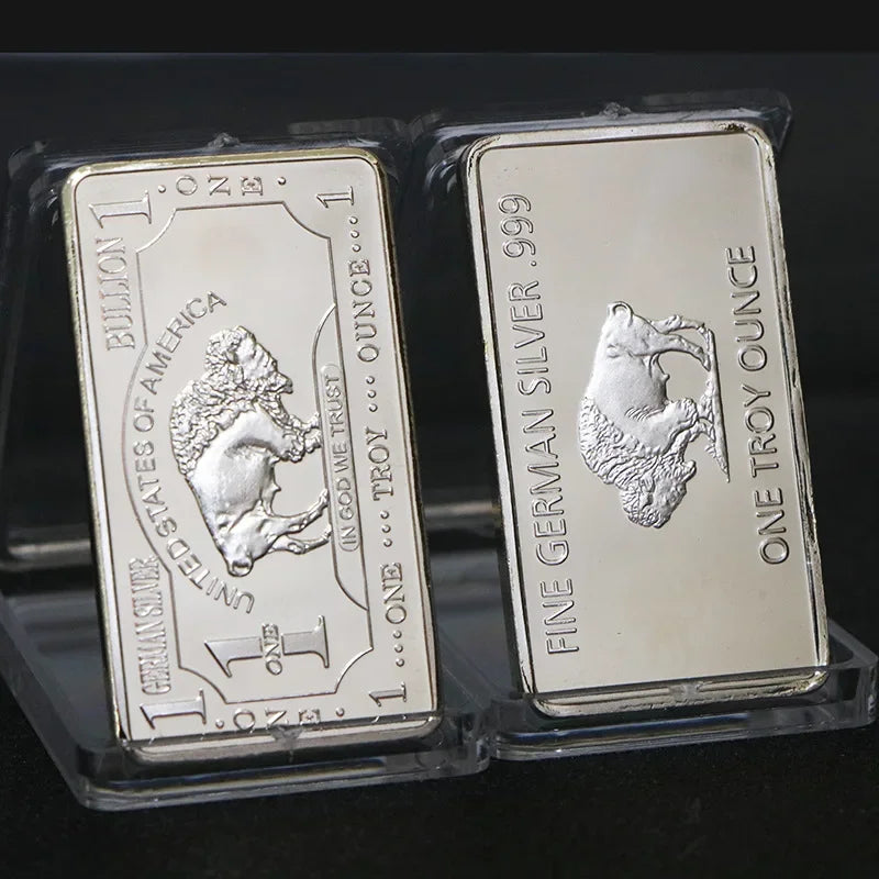 Two silver bullion bar replicas, one American and one German, are displayed in protective plastic packaging.
