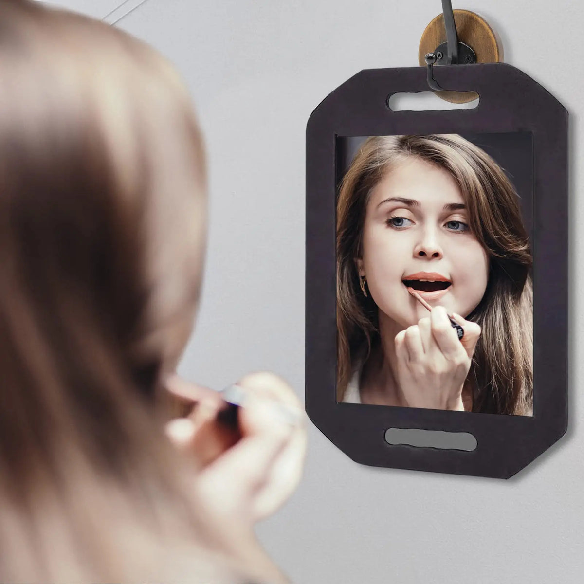 Espejo profesional de estilismo con protección de espuma mostrando el rostro de una mujer.