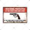 A vintage metal warning sign with text that reads This Home Protected by the Good Lord and a Gun and an image of a handgun.