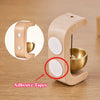 A wooden doorbell featuring a copper bell and adhesive tapes, shown in a close-up view.