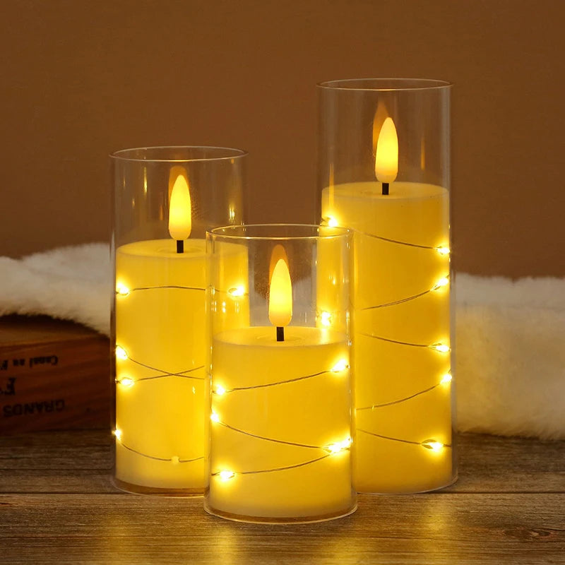 A set of yellow LED string candles in glass holders with flickering flames on a wooden surface.