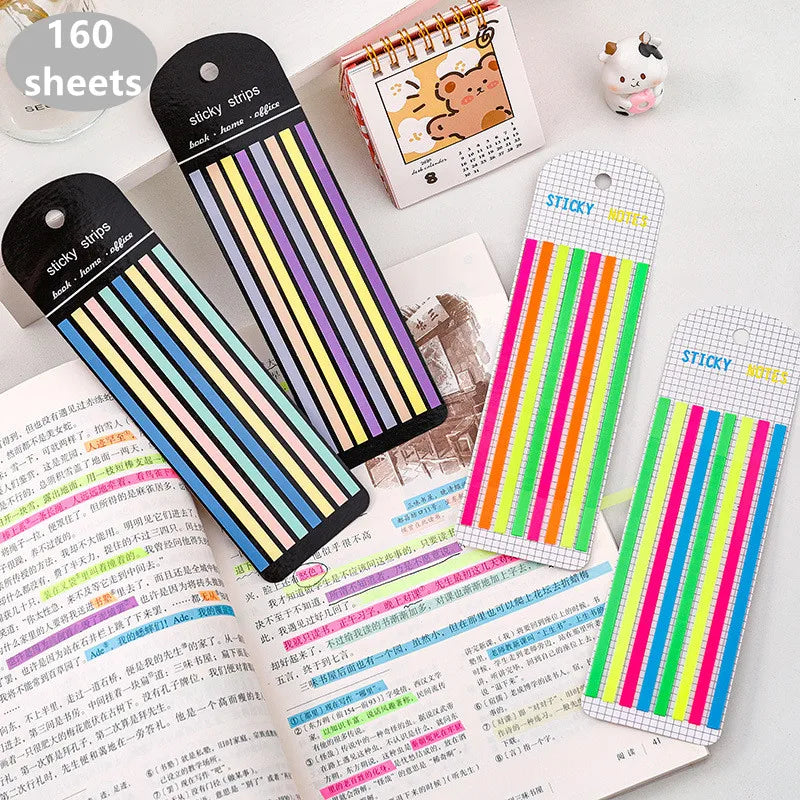A collection of 160 transparent sticky strips and index tabs in various colors and designs arranged on a white surface.