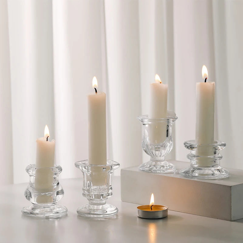 A collection of white candles in various glass holders displayed on a light surface.
