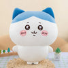A white and blue Usagi Chiikawa plush doll with large eyes sitting on a woven surface.