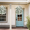 A light blue door decorated with white faux bougainvillea vines, set in a porch entryway.