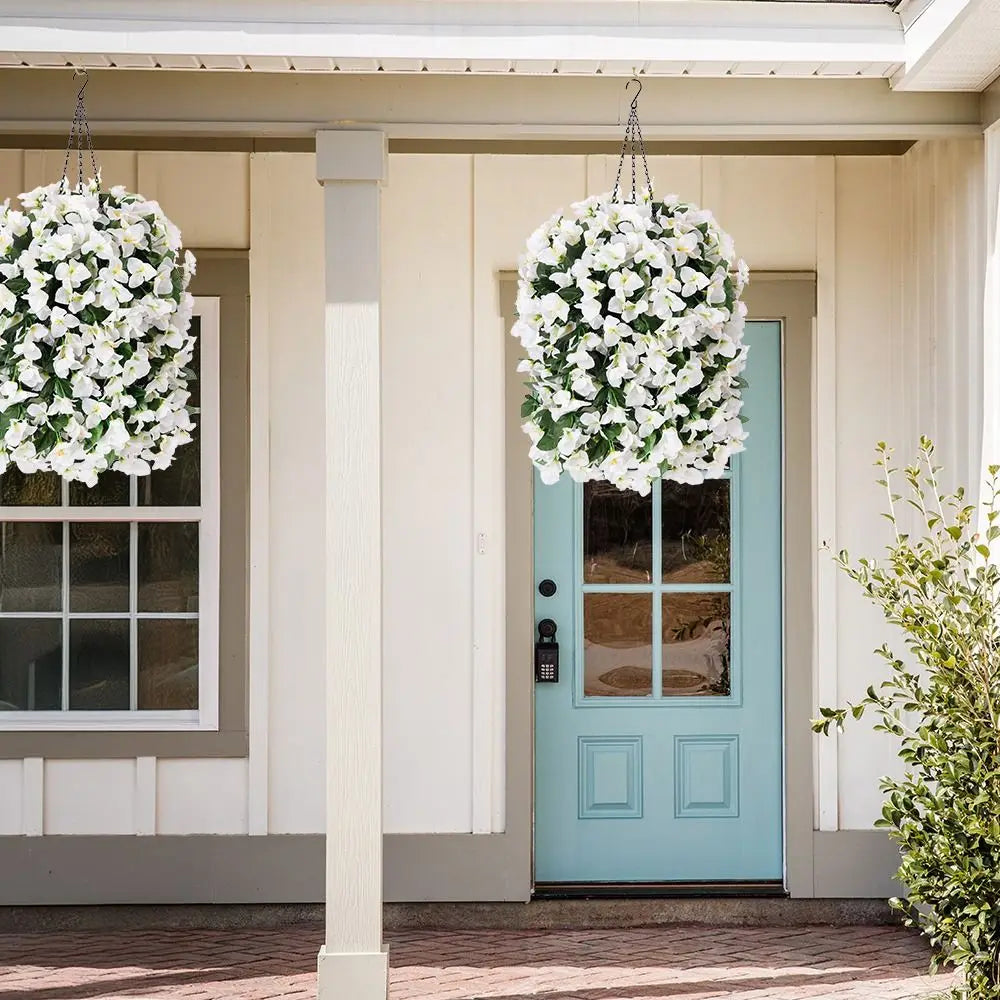 A light blue door decorated with white faux bougainvillea vines, set in a porch entryway.