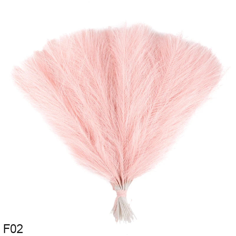 A fluffy pink artificial reed bouquet made of pampas grass with a tapered bottom.