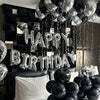 Silver alphabet and heart balloon set hanging against a black wall for party decorations
