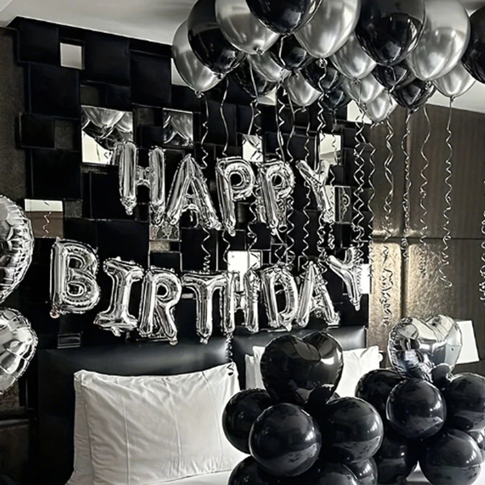 Silver alphabet and heart balloon set hanging against a black wall for party decorations