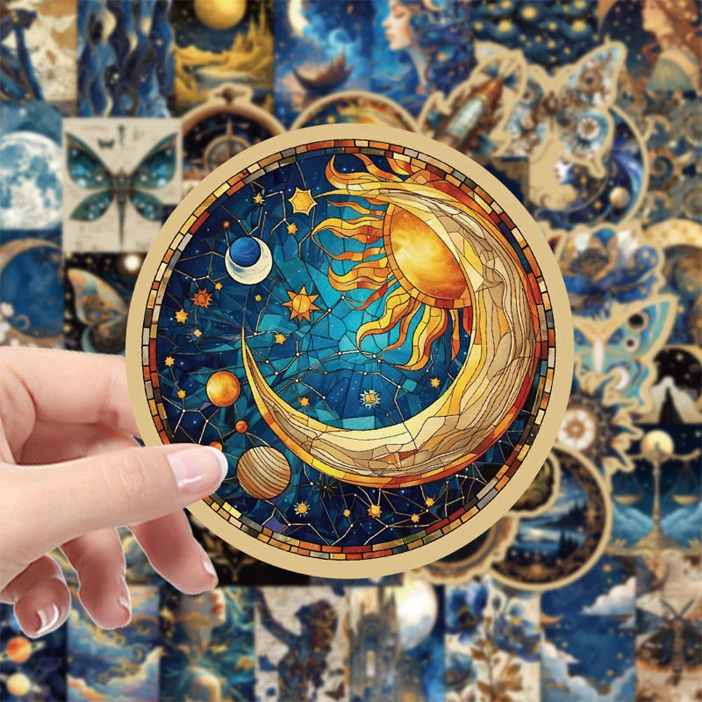 A hand holds a circular sticker featuring a stylized yellow and gold crescent moon with sun rays against a deep blue cosmic b