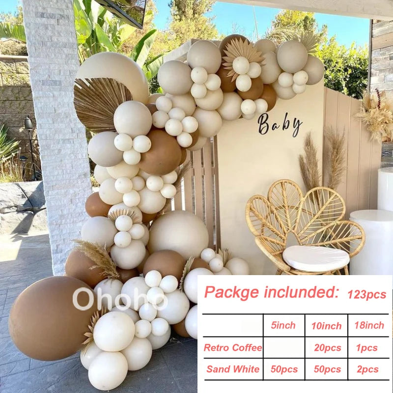 A display of beige and cream balloons arranged in a garland design against a light-colored wall.